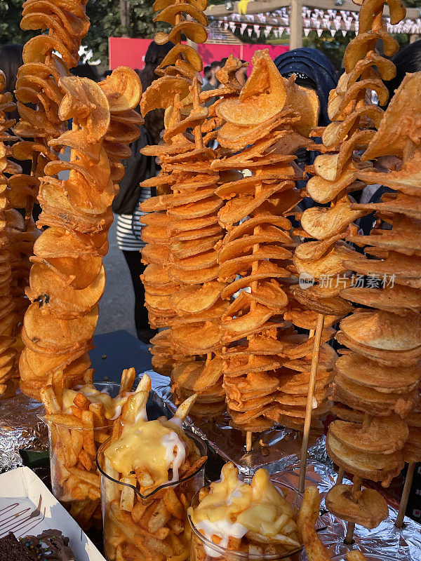 近距离图片，街边小吃摊上的木串上有辣味调味的油炸土豆螺旋，注意前景