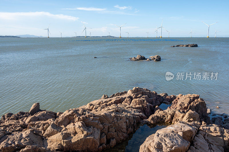 海边有岩石，海中央有风力