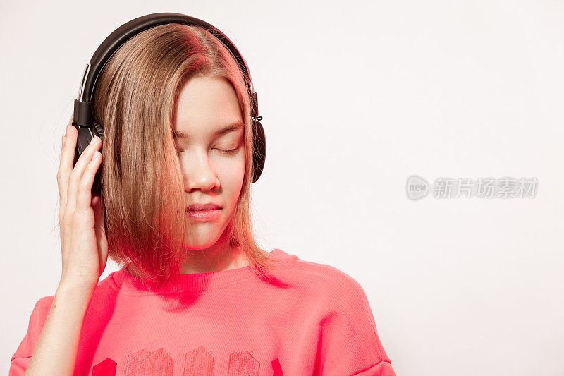 22岁快乐的亚洲女人用无线耳机听音乐