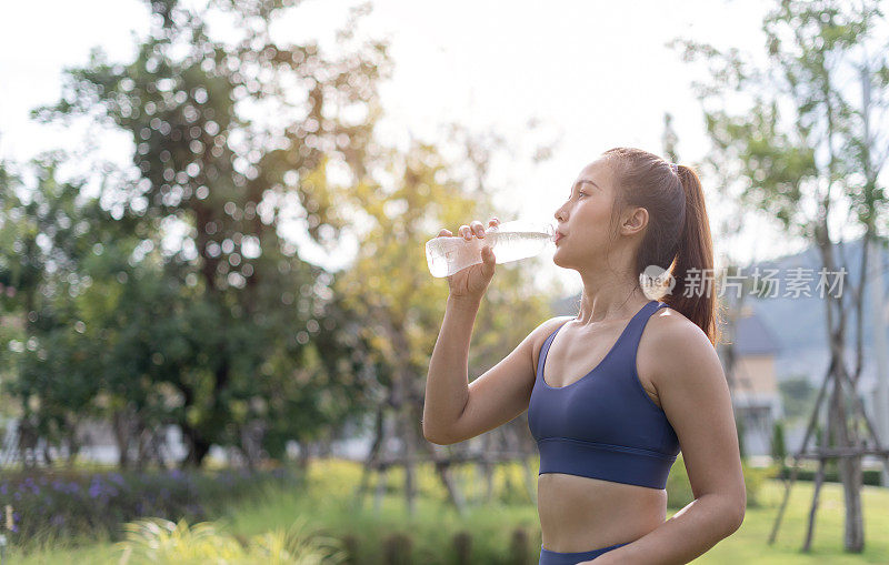 女人从瓶子里喝干净的水。女性健身后喝水。女性运动或运动后饮水。女运动员在锻炼后放松，喝水。