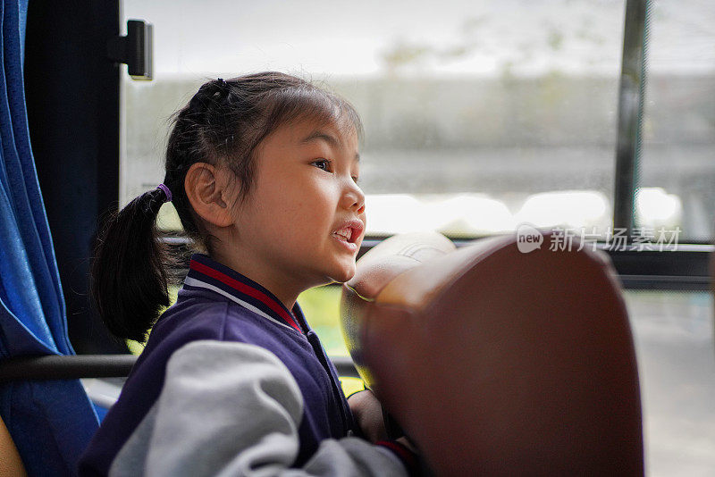 亚洲小女孩开心地乘坐公共汽车旅行