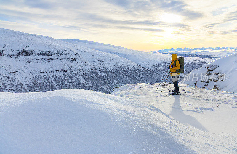 在一个阳光明媚的日子里，在Dovrefjell的山峰上穿雪鞋徒步旅行