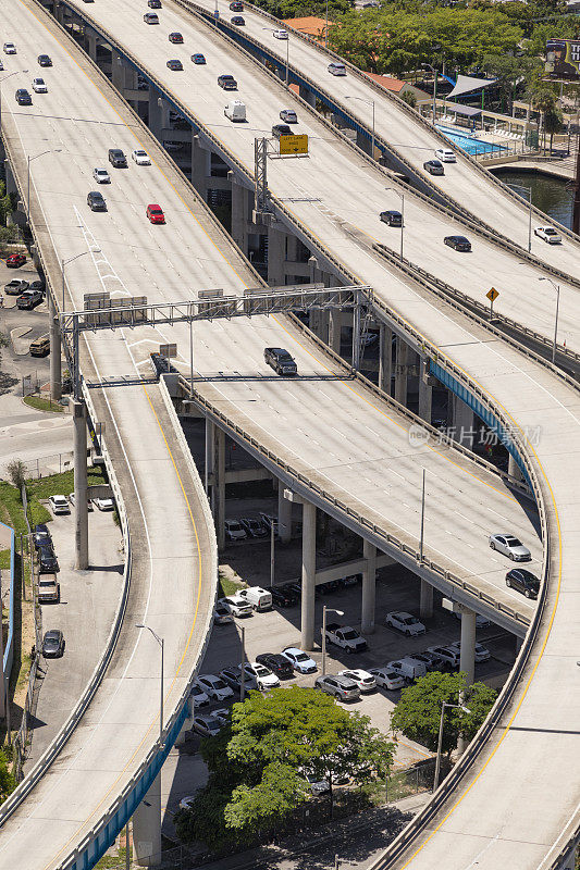 通过市中心和住宅区的高架道路上行驶的车辆的高角度视图。