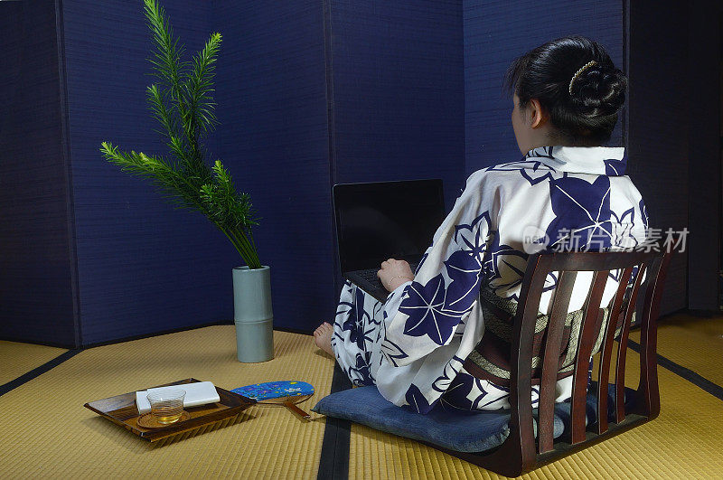 女性在日本传统教室里使用笔记本电脑