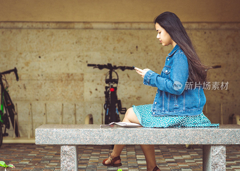 亚洲大学生在校室外使用手机