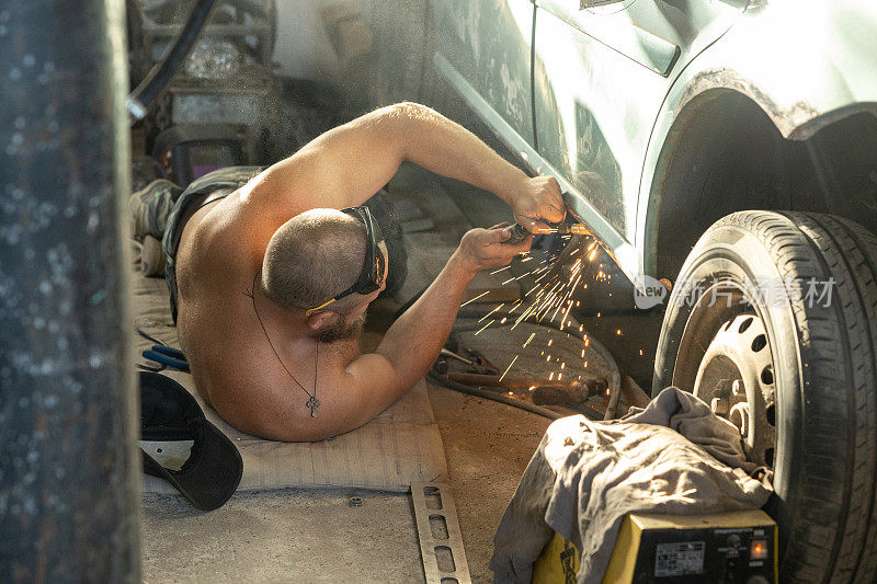 机械师用电焊机修理汽车门阀。