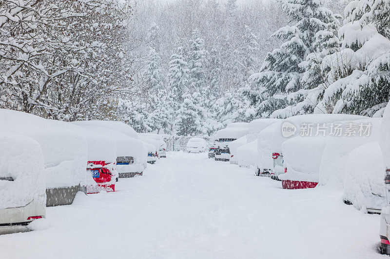 被大雪困住的汽车一动不动地停在房子院子里的雪地里