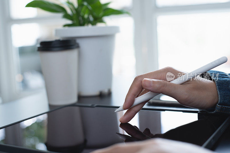 用数字平板电脑用触控笔拍摄女性手部特写，手指触摸屏幕，在家办公室在线工作。学生在线上课，通过电子阅读器移动应用程序阅读电子书