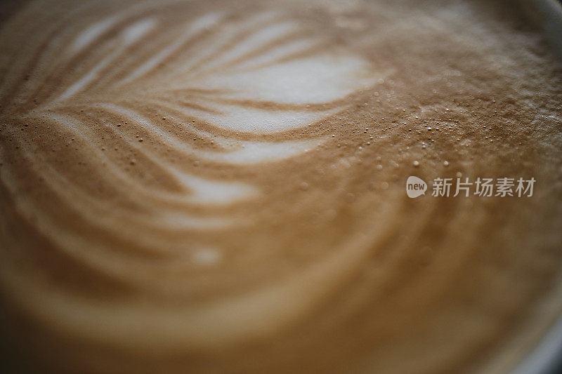 拿铁艺术的特写在一个扁平的白咖啡上。