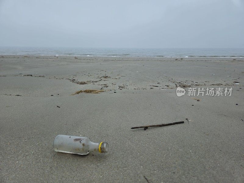 小塑料瓶躺在海滩岸边