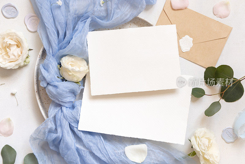卡片靠近浅蓝色薄纱织物结和奶油玫瑰在盘子上顶部查看复制空间，婚礼模型