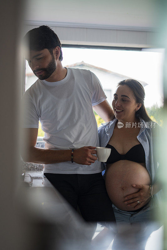 拉丁异性恋夫妇享受独处的时光，在生产前爱抚他们的肚子，加强他们作为夫妻的联系