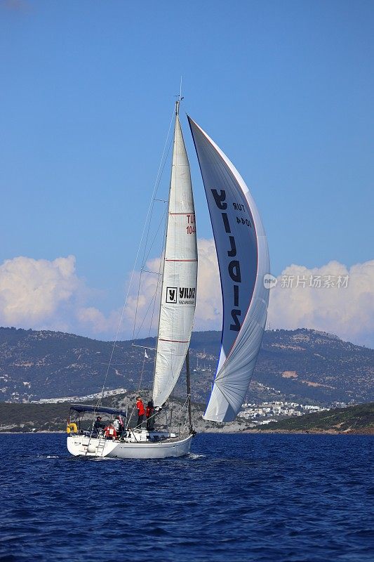 帆船在有风的天气里航行在爱琴海蔚蓝的海水中，在著名的度假胜地博德鲁姆的海岸上。