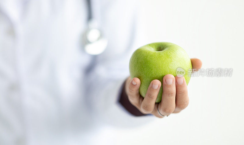 穿军大衣的短身女子，手里拿着苹果的医生