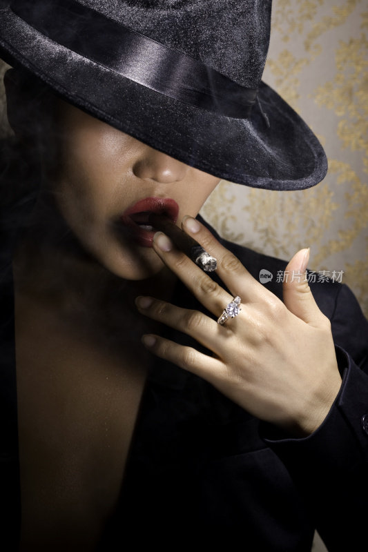 亚洲性感年轻女子肖像抽雪茄在30年代软呢帽