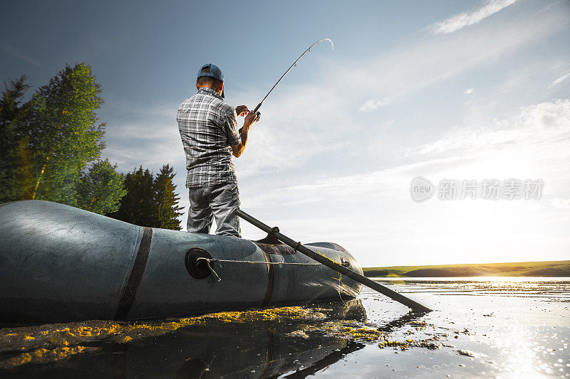 成熟的男人在湖边钓鱼
