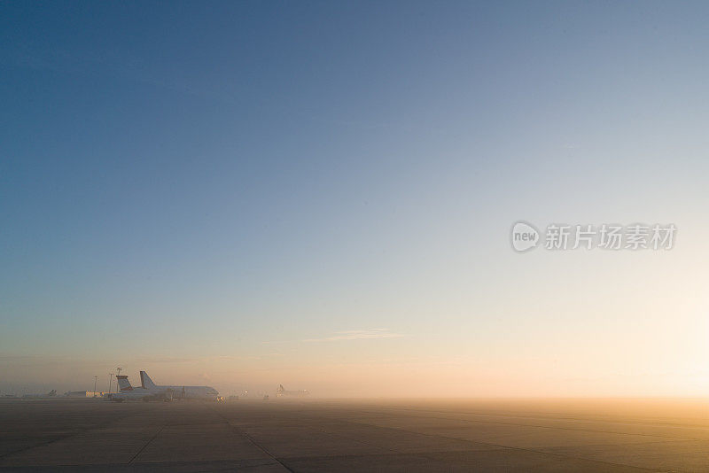 飞机在阳光明媚的清晨大雾中降落在机场
