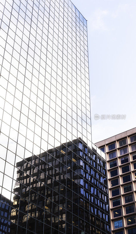 相邻的办公楼映在摩天大楼的窗户上
