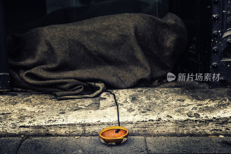 一个睡在意大利罗马街头的乞丐的乞讨碗