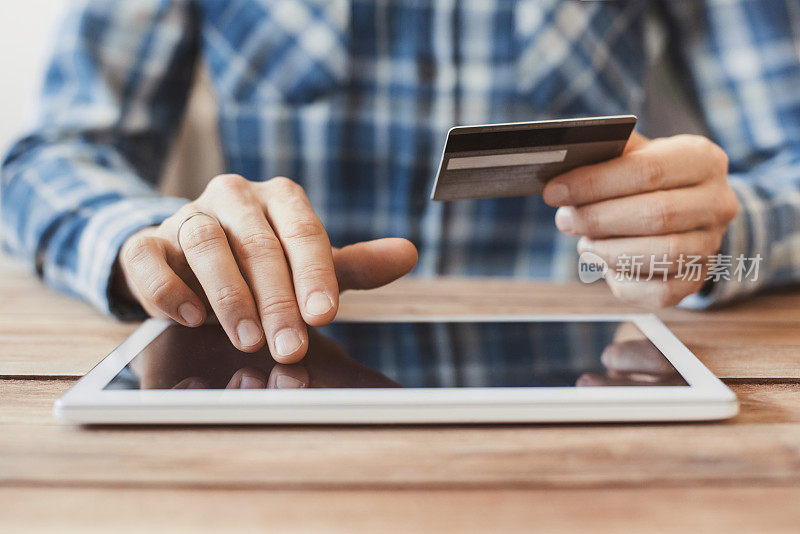男人用数字平板电脑和信用卡在网上购物
