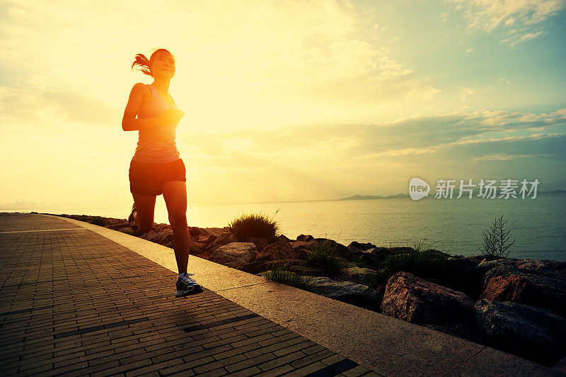 健康的生活方式亚洲妇女在日出的海边跑步