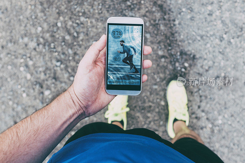 跑步者在跑步时手持智能手机和应用程序
