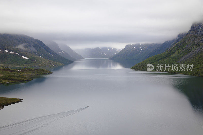 在一个雾天，快艇在湖上行驶。