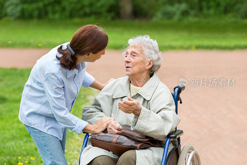 坐在轮椅上的老年妇女和家庭护理员