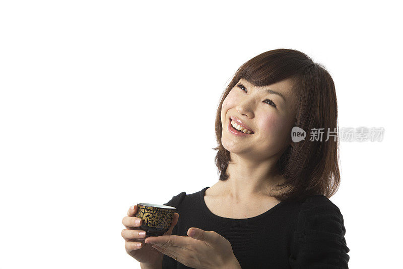 快乐的日本女人拿着茶杯