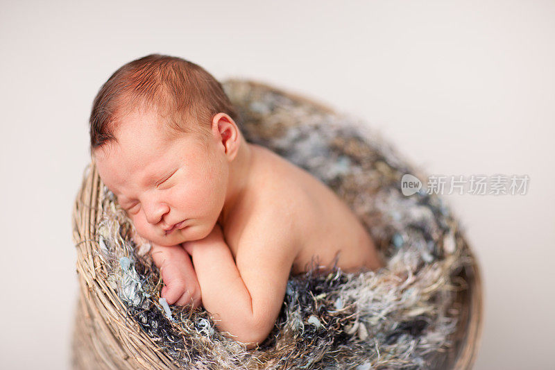 新生婴儿在毛茸茸的篮子里安静地睡觉