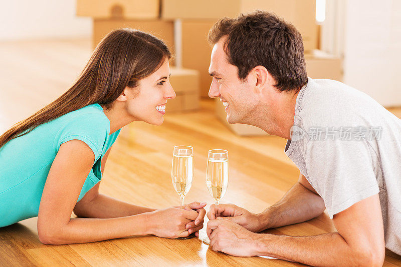 浪漫的夫妇在新房子里用香槟庆祝