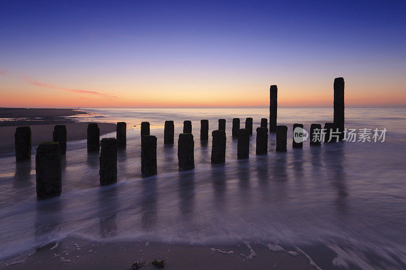 沿着荷兰海岸拍打着木制防波堤的海浪