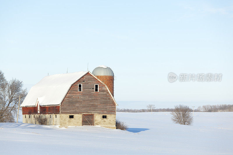 雪景中的乡村红谷仓和农田