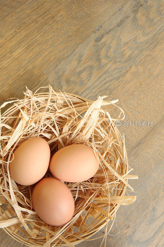 新鲜的农场鸡蛋在篮子在乡村木制背景