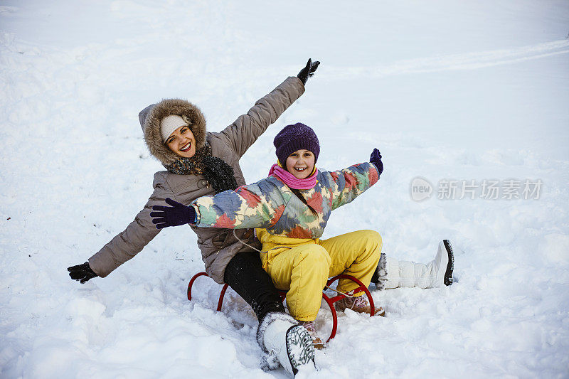 母亲和女儿喜欢坐雪橇