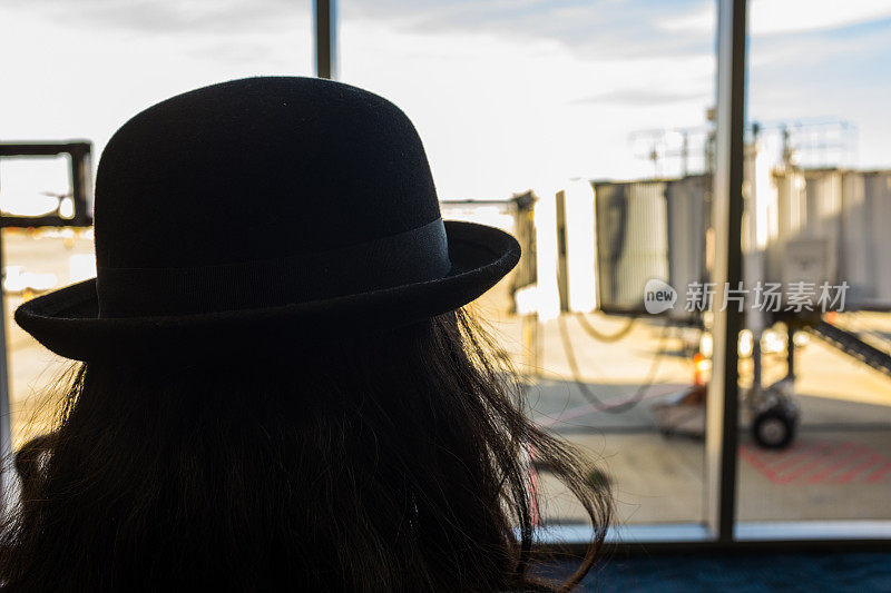 机场里一个留着长发戴着帽子的女人