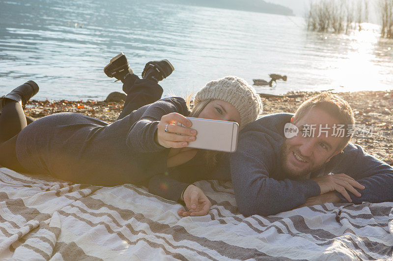 一对年轻夫妇在湖边放松自拍
