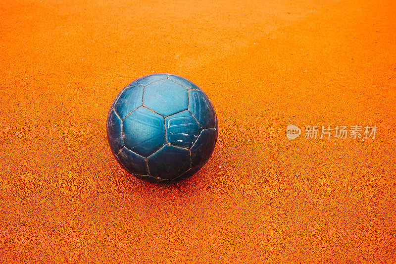 橙色地面上漂亮的蓝色足球
