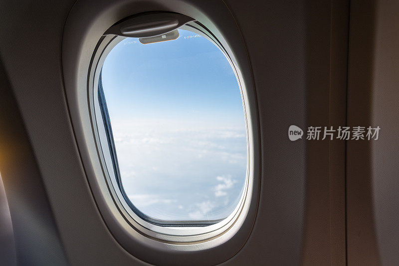 一架飞机的单一窗口，有云和蓝天
