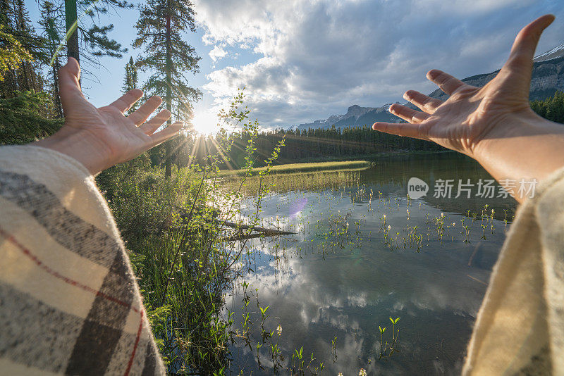 个人视角的女人在湖边伸开双臂