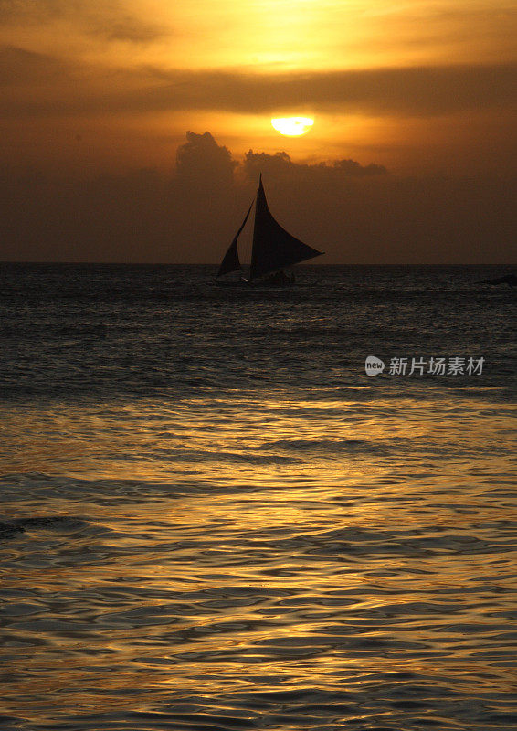 日落时分，菲律宾长滩岛白色海滩上的小船