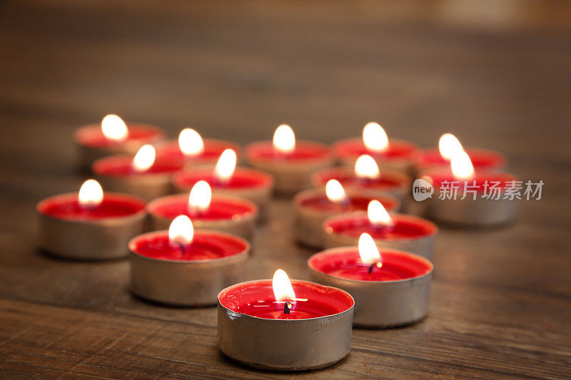 棕色的木桌上放着红色的蜡烛