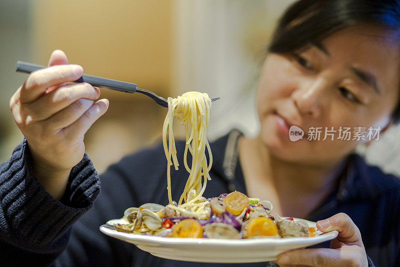 女孩品尝海鲜面食