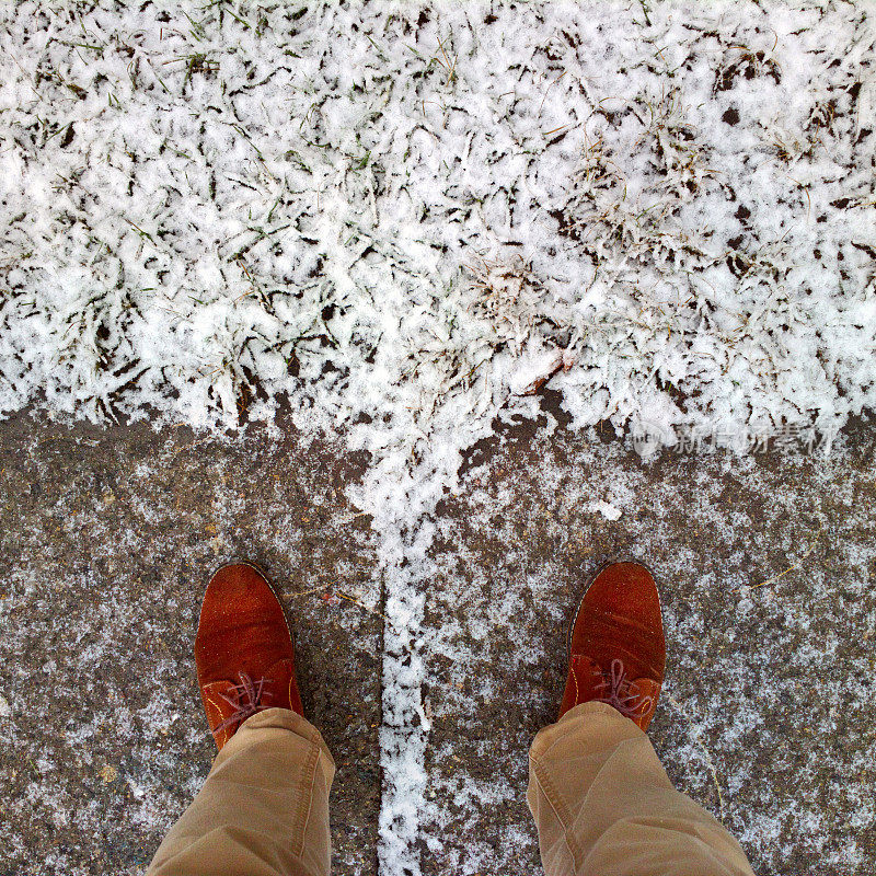 脚踩着被雪覆盖的地面。草地上覆盖着雪。脚踩在雪地里。