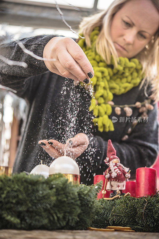 用人造雪装饰圣诞花环的女人