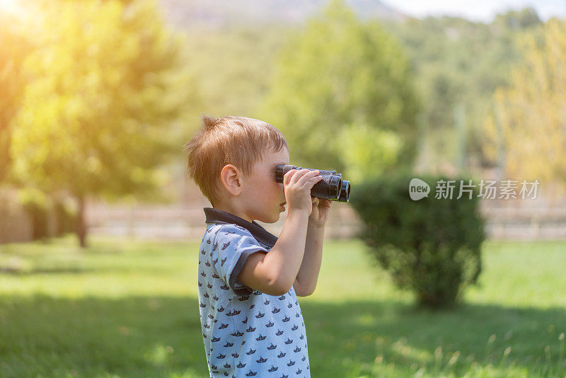 男孩用双筒望远镜看