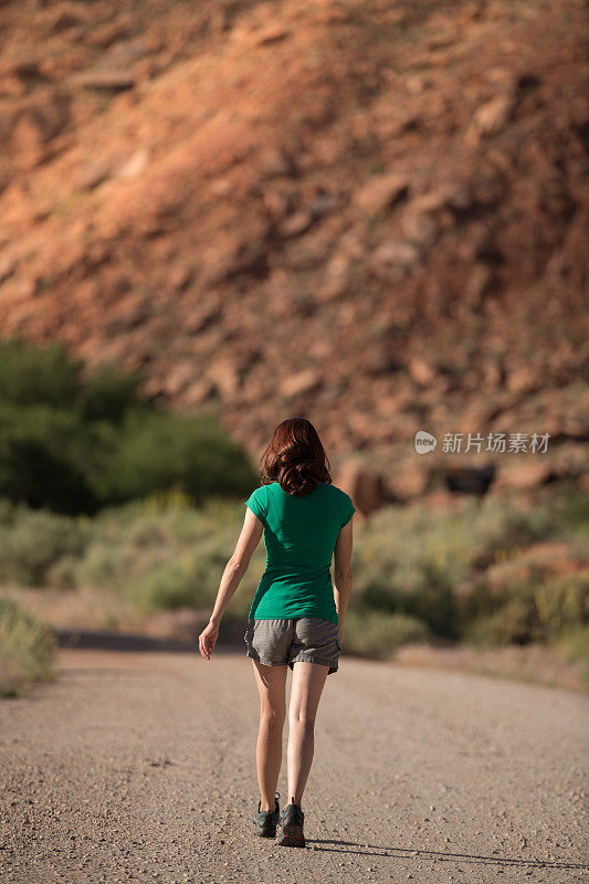 徒步妇女享受犹他州的壮观的自然日出