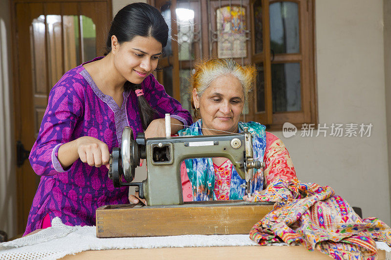 母亲和女儿缝纫库存图像