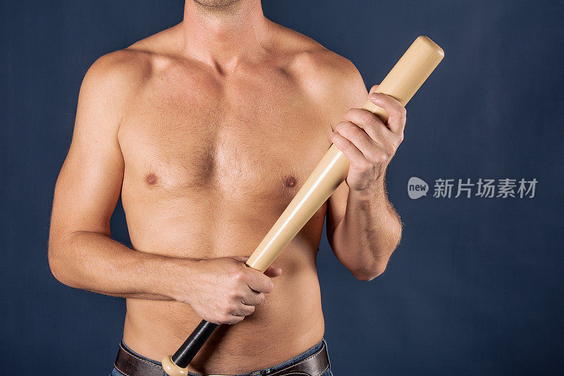 上身赤裸的男人在蓝色背景上拿着棒球棒