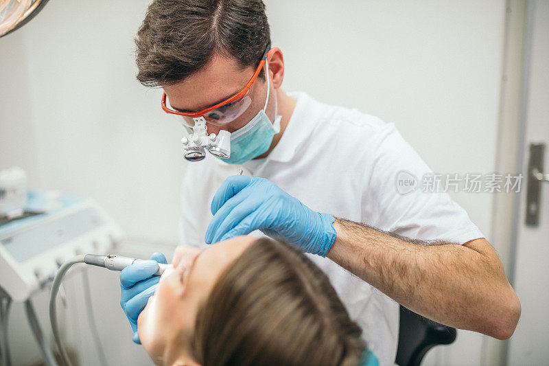 牙医为一位女士检查牙齿